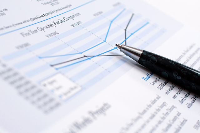 A pen lays on top of a financial report.